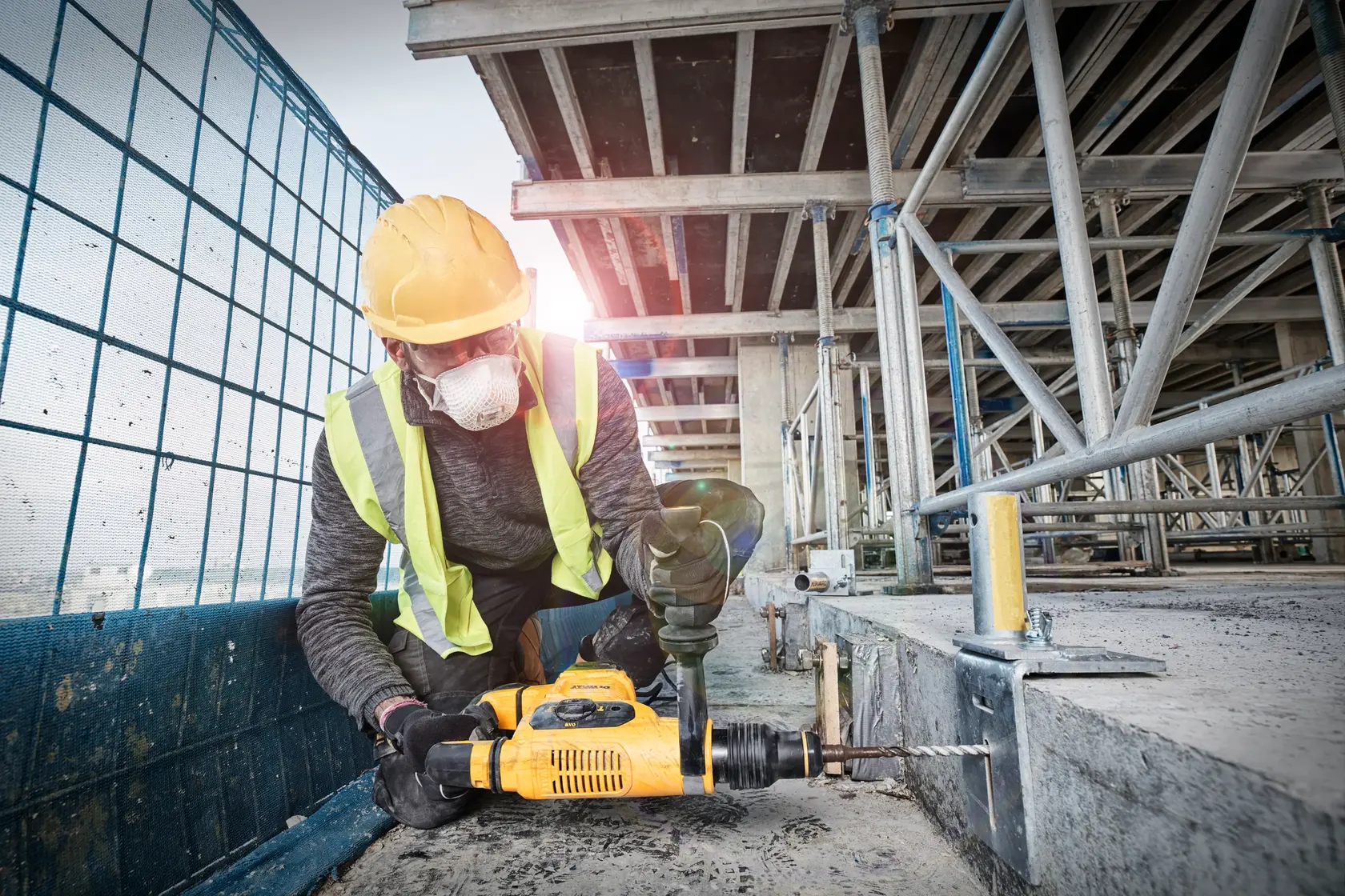 Photo of worker with DEWALT rotary hammer, SKUs D25810K-B3, D25810K-B2, D25810K-QS, D25810K-AR, D25810K at site.