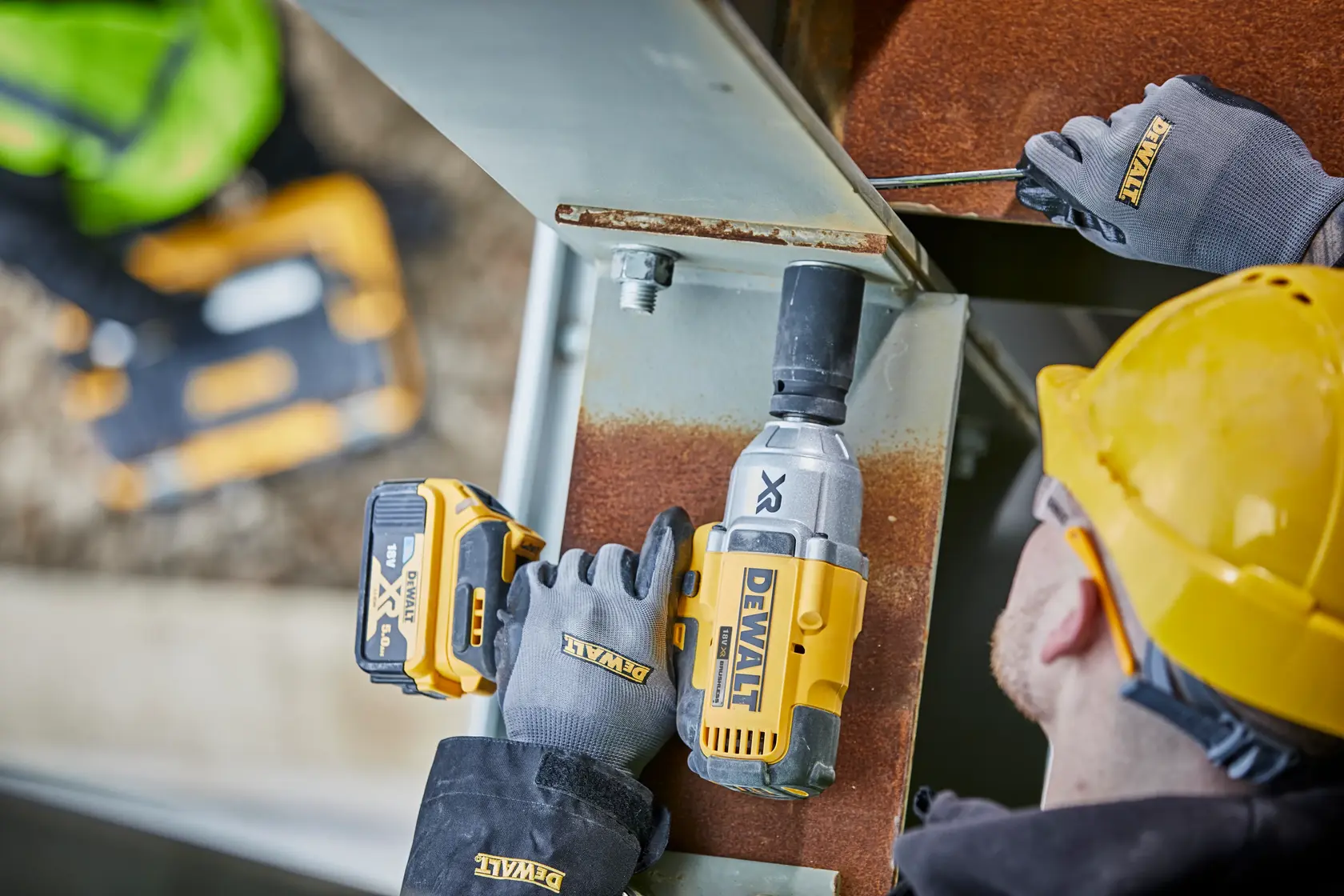 DEWALT DCF897N-XJ, DCF897N impact wrench in use on steel beam, operator with gloves and hard hat, construction site.