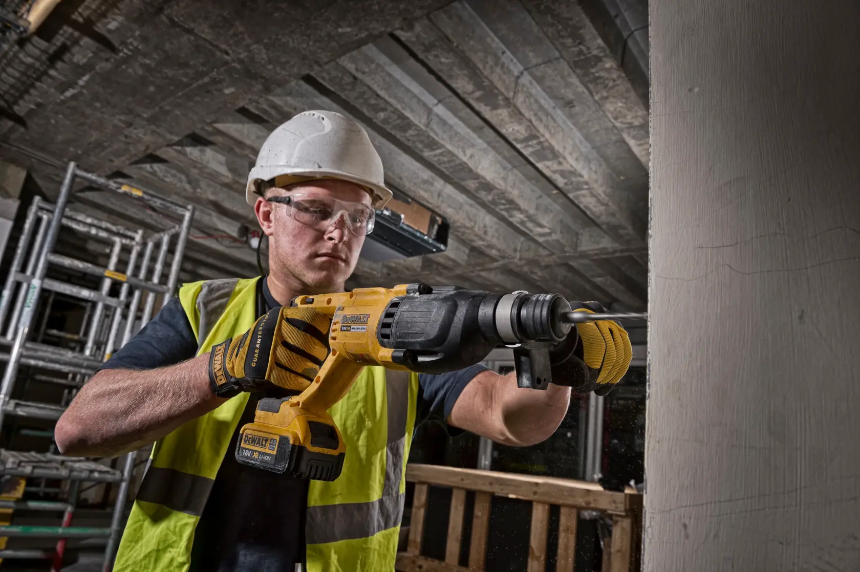 Worker uses DEWALT DCH133M1-QW, DCH133M1 rotary hammer drill at construction site. Photography product category.